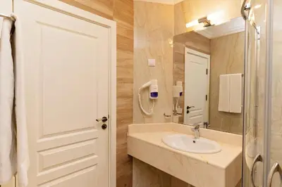 a bathroom with a sink and a mirror at Burgas Beach Resort Apartments in Burgas City