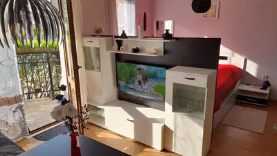 a living room with a tv in a white entertainment center at Alex Deluxe Apartments in Sunny Beach