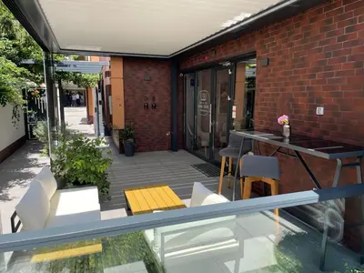 a patio with a table and chairs and a brick building at Caro Apartments & Rooms in Varna City