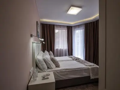 a hotel room with a bed and a window at Caro Apartments & Rooms in Varna City