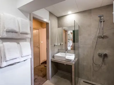 a bathroom with a sink and a shower at Caro Apartments & Rooms in Varna City