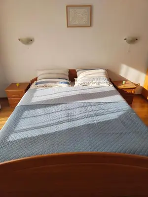a large bed in a bedroom with a blue comforter at Guest Rooms Melsambria in Nesebar