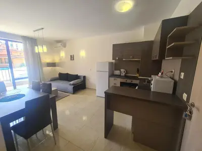 a kitchen and a living room with a table in a kitchen at Private Apartment in Star Dreams Complex in Sveti Vlas