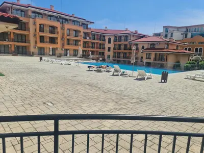 a courtyard with chairs and a swimming pool with buildings at Private Apartment in Star Dreams Complex in Sveti Vlas