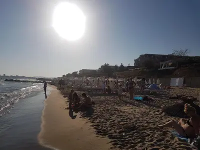 a group of people sitting on a beach at Private Apartment in Star Dreams Complex in Sveti Vlas