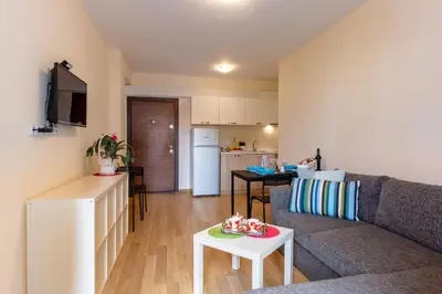 a living room and kitchen with a couch and a table at Apartments Flora in Burgas City