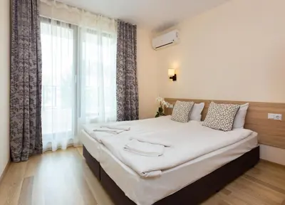 a large bed in a room with a large window at Apartments Flora in Burgas City