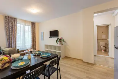 a living room with a table and chairs and a couch at Apartments Flora in Burgas City