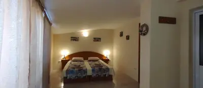 a bedroom with a bed and two lights on the wall at Rooms Via Maris in Sozopol