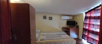 a small bedroom with a bed and a television at Rooms Via Maris in Sozopol