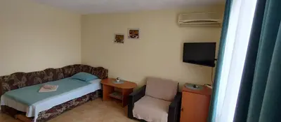 a small bedroom with a bed and a chair at Rooms Via Maris in Sozopol