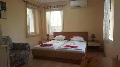 a small bedroom with a bed and a chair at Cathedral Guesthouse in Varna City
