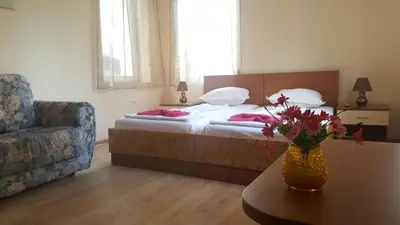 a bedroom with a bed and a table with a vase of flowers at Cathedral Guesthouse in Varna City