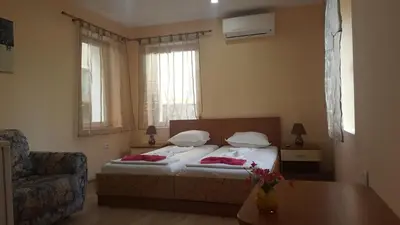 a bedroom with a bed and a chair and a table at Cathedral Guesthouse in Varna City