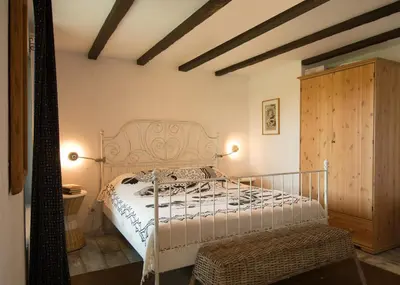 a bedroom with a white bed and a wooden cabinet at Art Provence House in Lozenets