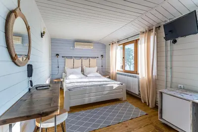 a bedroom with a bed and a table and a mirror at St Anastasia Hotel in Burgas City