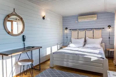 a bedroom with blue walls and a bed and a desk at St Anastasia Hotel in Burgas City
