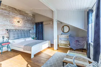 a bedroom with a bed and a brick wall at St Anastasia Hotel in Burgas City