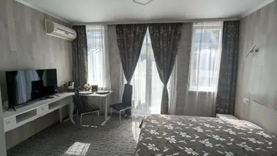 a bedroom with a bed and a desk and a television at Apartments Iris69 in Varna City