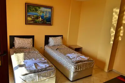 a room with two beds and a picture on the wall at Joro Guest House in Sveti Vlas