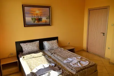 a bedroom with two beds and a painting on the wall at Joro Guest House in Sveti Vlas