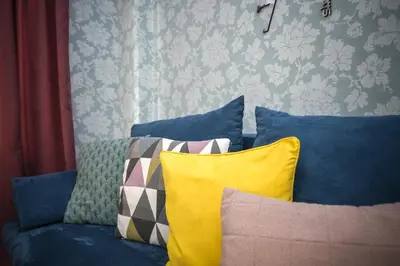 a blue couch with pillows in a room at The Cozy Apartment in Varna City