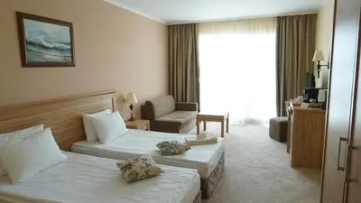 a hotel room with two beds and a couch at DIT Evrika Beach Club Hotel - All Inclusive in Sunny Beach