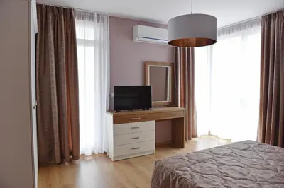 a bedroom with a bed and a television on a dresser at Apartments Lucky Complex Ravda in Ravda