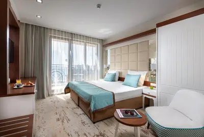 a hotel room with a bed and a chair at Festa Via Pontica in Pomorie