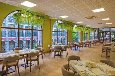a dining room with tables and chairs and windows at Festa Via Pontica in Pomorie