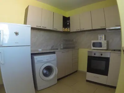 a kitchen with a washing machine and a refrigerator at Holidays apartment Bourgas in Burgas City
