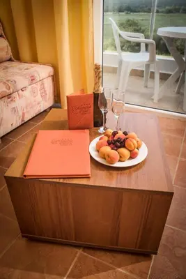 a plate of fruit and wine glasses on a table at Hotel Plamena Palace in Primorsko