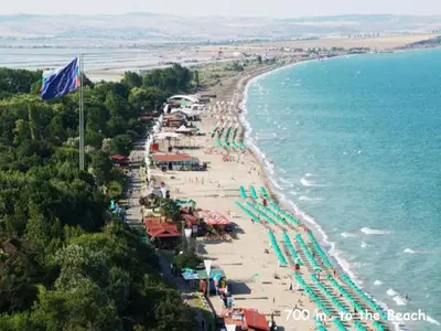 a beach with umbrellas and chairs and the ocean at 4U Apartment - Gurko in Burgas City