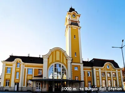 a large yellow building with a clock tower at 4U Apartment - Gurko in Burgas City