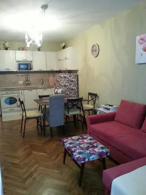 a living room with a red couch and a table at Florata apartment in Burgas City