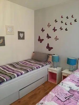a bedroom with two beds and butterflies on the wall at Florata apartment in Burgas City