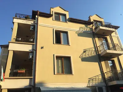 a yellow building with balconies and a blue sky at ART Apartments - Pomorie in Pomorie