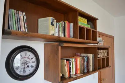 a clock on a book shelf with books at ART Apartments - Pomorie in Pomorie