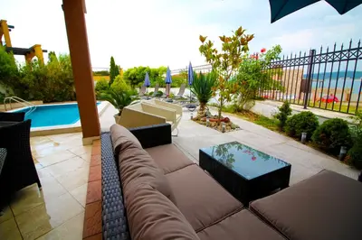 a patio with a couch and a table and a pool at Luxury House on Buzhaka in Sozopol