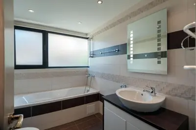 a bathroom with a sink and a tub and a mirror at Luxury House on Buzhaka in Sozopol