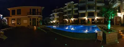 a swimming pool in front of a building at night at Boulevard Sea Residence in Sunny Beach