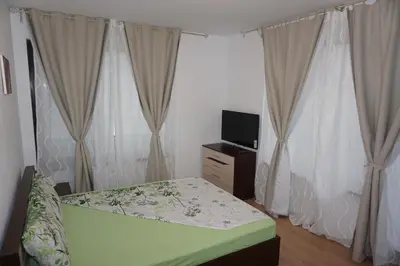 a bedroom with a bed and a tv and curtains at Boulevard Sea Residence in Sunny Beach
