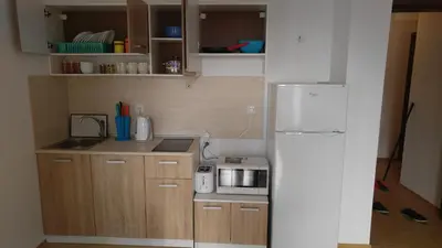 a small kitchen with a stove and a refrigerator at Boulevard Sea Residence in Sunny Beach