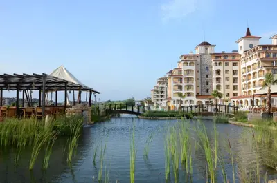 a river in a city with buildings and a bridge at Sunrise All Suites Resort- All Inclusive in Obzor