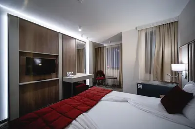 a hotel room with a large bed and a desk at Saint George Hotel & Medical Spa in Pomorie