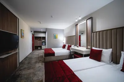 a hotel room with two beds and a television at Saint George Hotel & Medical Spa in Pomorie