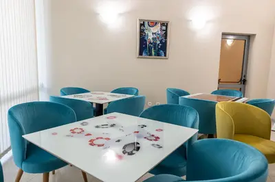 a waiting room with two tables and blue chairs at Hotel Neptun Beach in Sunny Beach