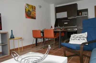 a living room with a couch and a table with chairs at Apartments Helios in Pomorie