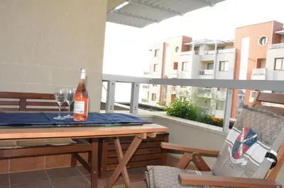 a bottle of wine sitting on a table on a balcony at Apartments Helios in Pomorie