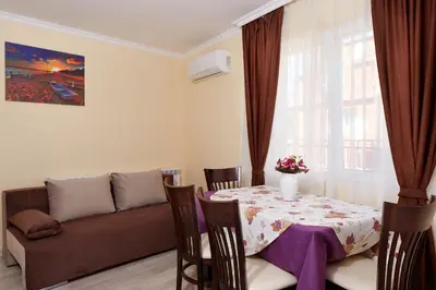 a living room with a table and a couch at Feniks Apartments in Nesebar